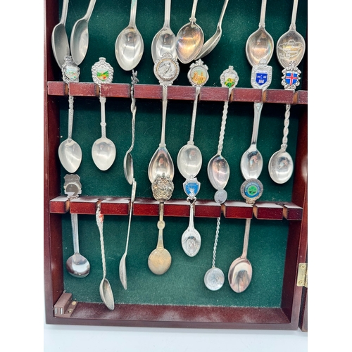 165 - Collection of collectable tea spoons in display case