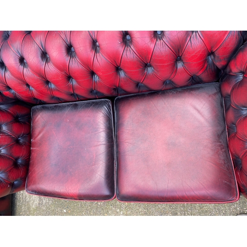 202 - Two crimson leather chesterfield sofas.