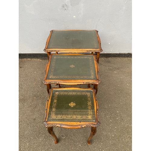 604 - Antique serpentine nest of three tables with inlaid green leather and glass protective tops. 

Dimen... 