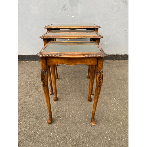 604 - Antique serpentine nest of three tables with inlaid green leather and glass protective tops. 

Dimen... 