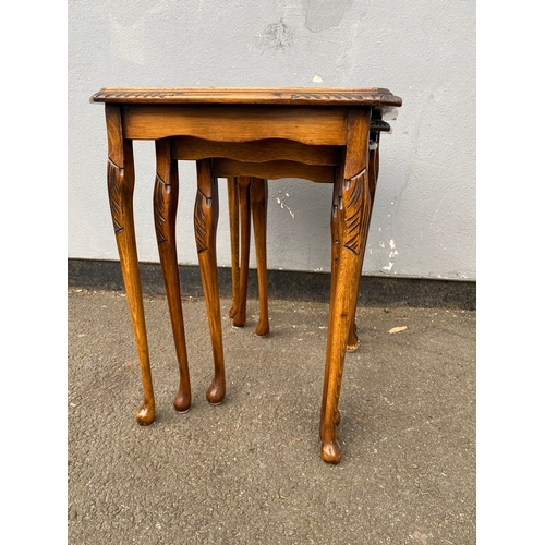 604 - Antique serpentine nest of three tables with inlaid green leather and glass protective tops. 

Dimen... 