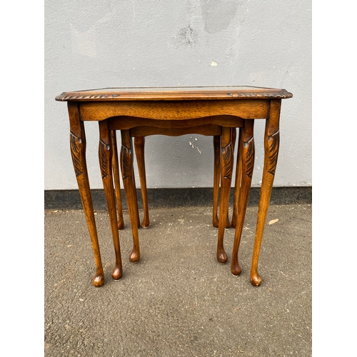 604 - Antique serpentine nest of three tables with inlaid green leather and glass protective tops. 

Dimen... 