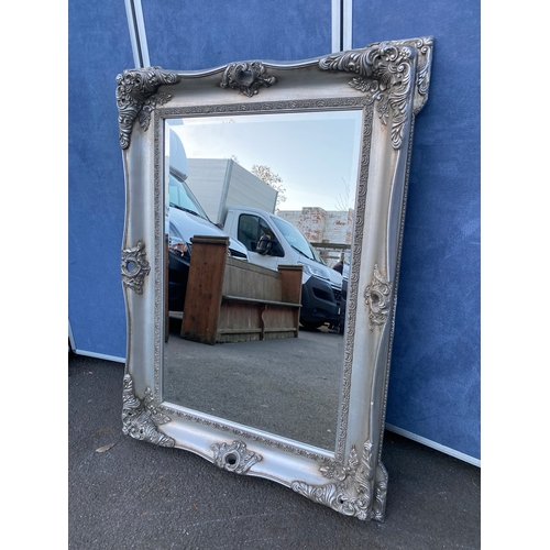 620 - Ornate rectangular silver framed bevelled edge mirror. 

Dimensions - 35