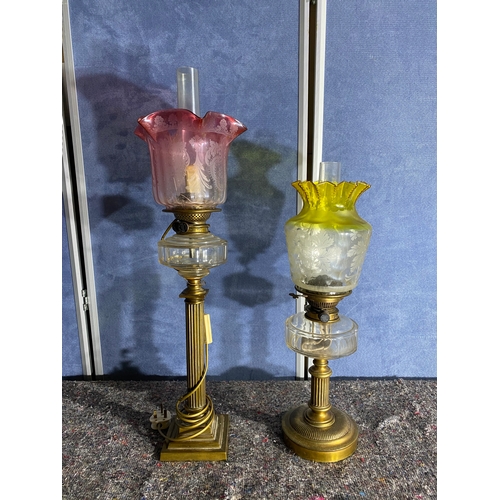 565 - A pair of brass and coloured glass etched shades paraffin lamps. One has been converted