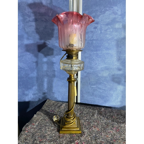 565 - A pair of brass and coloured glass etched shades paraffin lamps. One has been converted