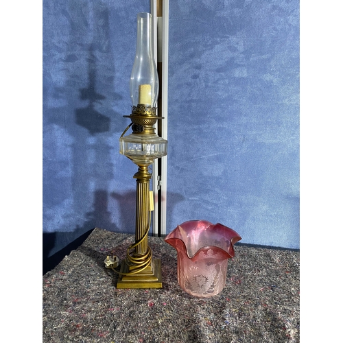 565 - A pair of brass and coloured glass etched shades paraffin lamps. One has been converted