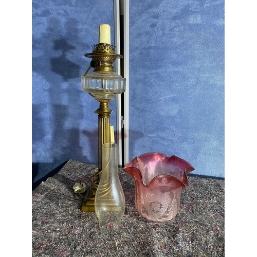 565 - A pair of brass and coloured glass etched shades paraffin lamps. One has been converted