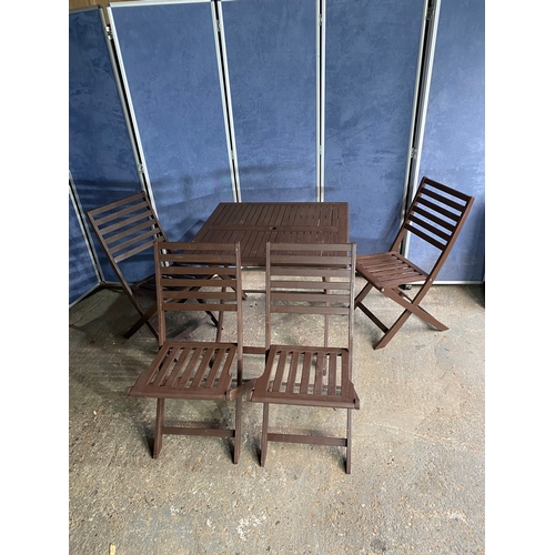 580 - Lightweight foldable wooden garden table and four chairs.