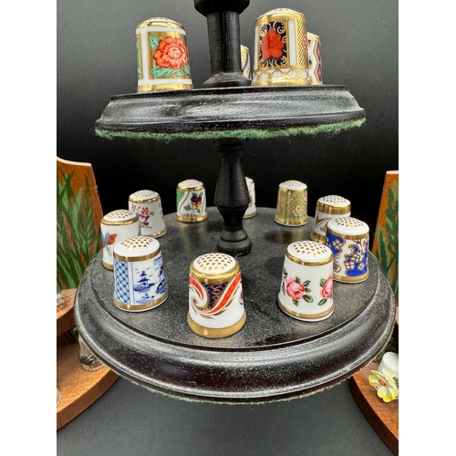 87 - Collection of decorative thimbles including Crown Derby Collection on display stands / cabinets