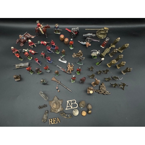 253 - A collection of early 20th century lead toy soldiers, cowboys + military badges