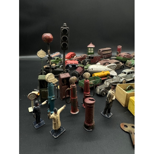 254 - A collection of  early 20th century tin plate and die cast metal model cars, petrol pumps / accessor... 