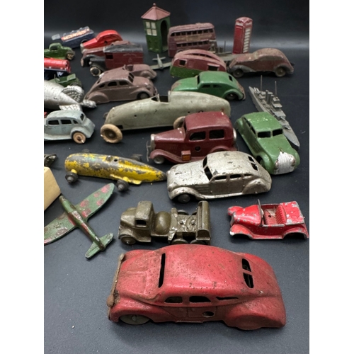 254 - A collection of  early 20th century tin plate and die cast metal model cars, petrol pumps / accessor... 