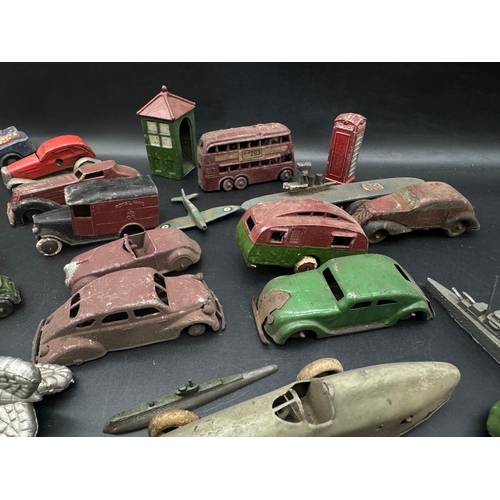 254 - A collection of  early 20th century tin plate and die cast metal model cars, petrol pumps / accessor... 