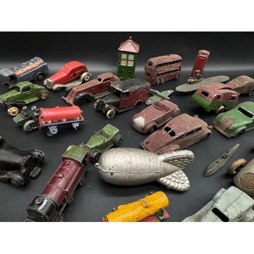 254 - A collection of  early 20th century tin plate and die cast metal model cars, petrol pumps / accessor... 