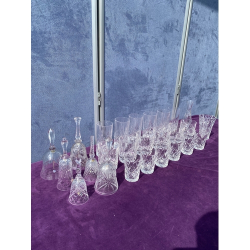 83 - A collection of crystal drinking glasses, bells and two small vases