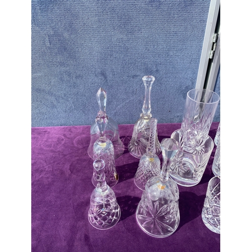 83 - A collection of crystal drinking glasses, bells and two small vases