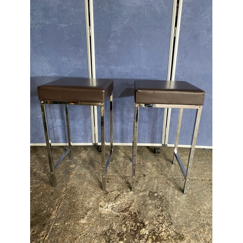 222 - A modern slimline chrome leg table and two stools.