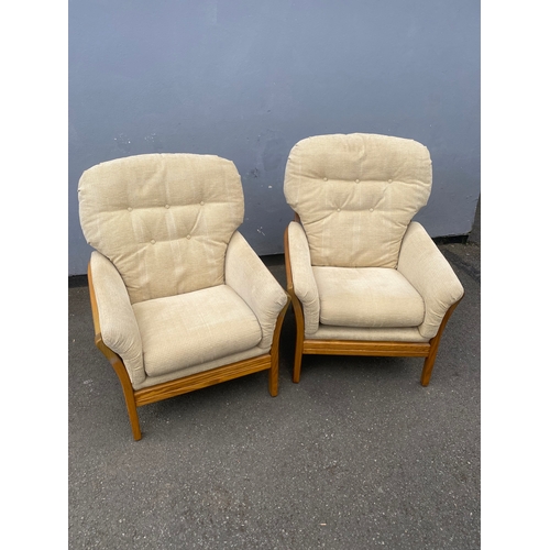 284 - A pair of mid century teak framed upholstered arm chairs.