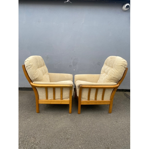 284 - A pair of mid century teak framed upholstered arm chairs.