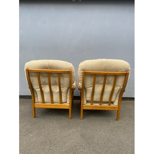 284 - A pair of mid century teak framed upholstered arm chairs.