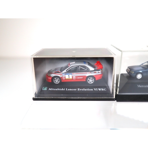 106 - Collection of 1:64 Scale cased model cars including Subaru Impreza WRC, Lancer Evolution WRC, BMW's ... 