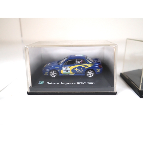 106 - Collection of 1:64 Scale cased model cars including Subaru Impreza WRC, Lancer Evolution WRC, BMW's ... 