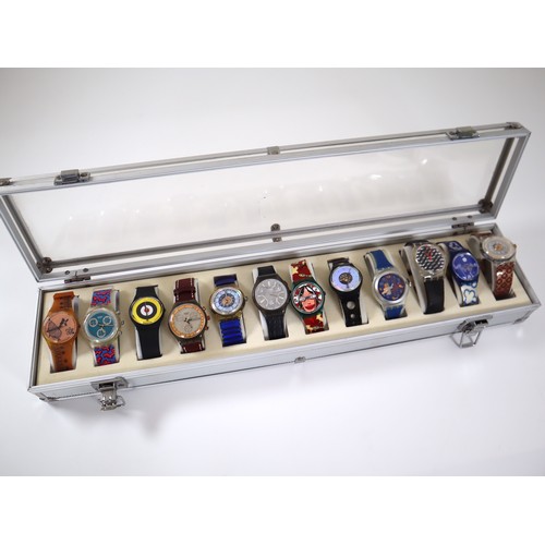 174 - 12 x Collectable Swatch Watches in Aluminium Display Case