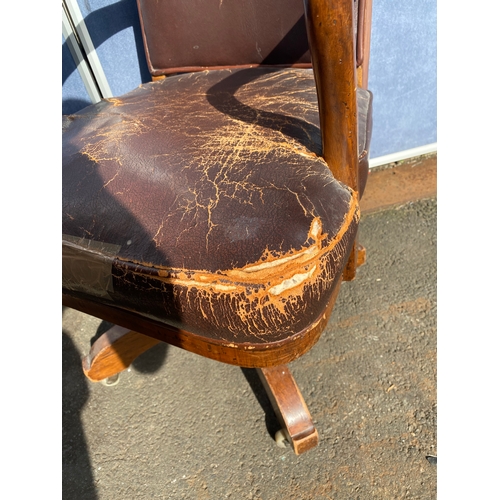 658 - A vintage leather swivel office chair and rattan seat/back arm chair.