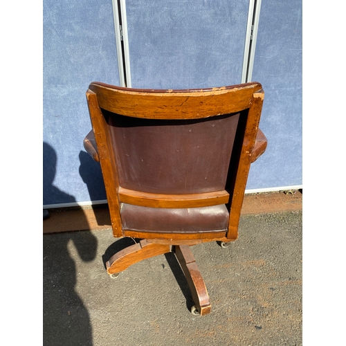 658 - A vintage leather swivel office chair and rattan seat/back arm chair.