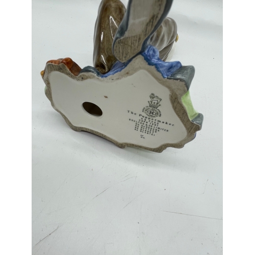 290 - Three ceramic ornaments including Royal Doulton 'The old Balloon seller', 'The Puppet maker'