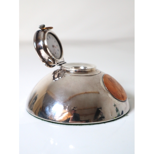 98 - Sterling Silver Inkwell revealing a white enamelled pocket clock with copper oval monogram