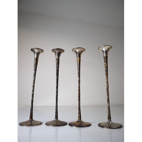 147 - A matched set of four Solid Silver candlestick holders by Stuart Devlin, the tapering parcel gilt st... 