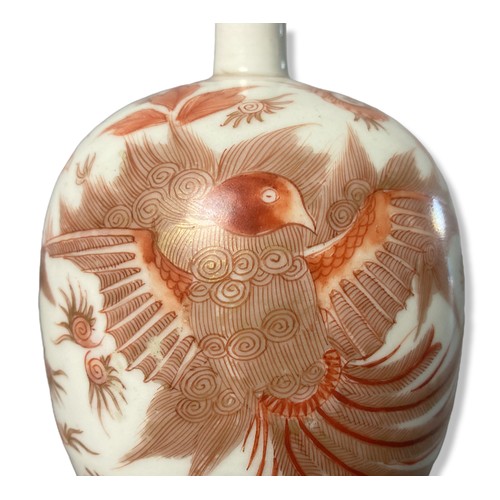 188 - A fine quality porcelain bottle vase painted in Iron red, depicting a rising Phoenix with stylised f... 