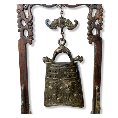 114 - A Chinese temple bell / gong with carved wooden stand. The bell relief decorated with Guardian Lions... 