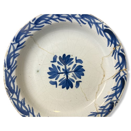 71 - An 18th-century Delft ware plate. Central floral motif with similar border pattern.  Repaired.
22cm ... 