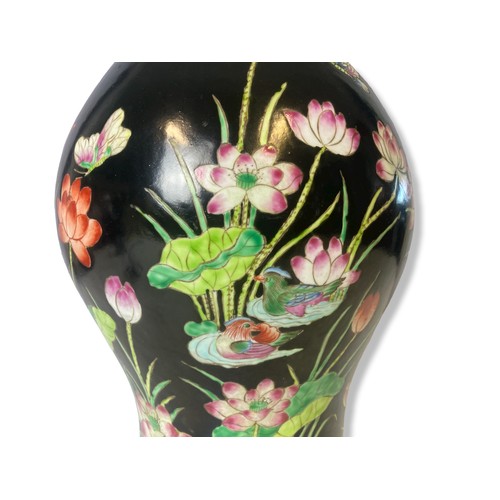 212 - A Chinese black ground enamels painted vase. Depicting pond scenes with lilies, birds and insects in... 