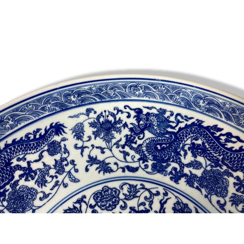 221 - A large Chinese porcelain 5-claw Dragon dish. Depicting a central Dragon amongst blossoming out-crop... 