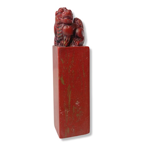 129 - A Chinese carved Chicken blood stone sea. Carved with a carved Foo dog to top.
12cm tall