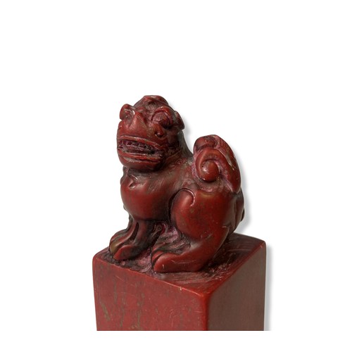 129 - A Chinese carved Chicken blood stone sea. Carved with a carved Foo dog to top.
12cm tall