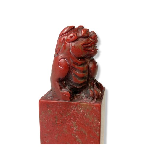 129 - A Chinese carved Chicken blood stone sea. Carved with a carved Foo dog to top.
12cm tall