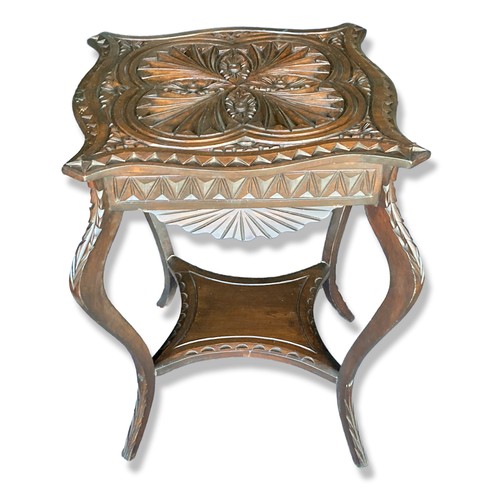 288 - A Carved oak occasional / Wine table. Carved with an Art Nouveau stylised pattern, with cabriole leg... 