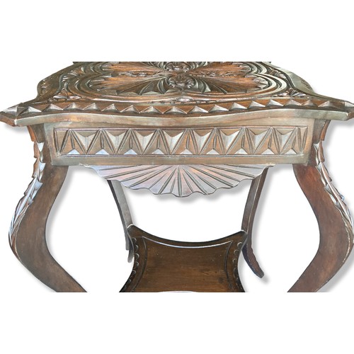 288 - A Carved oak occasional / Wine table. Carved with an Art Nouveau stylised pattern, with cabriole leg... 