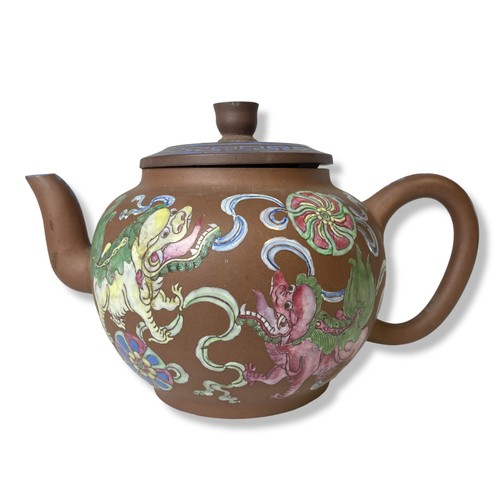 263 - A 19th-century Chinese Yixing teapot. Hand-painted in over-glaze enamels depicting Lions playing wit... 