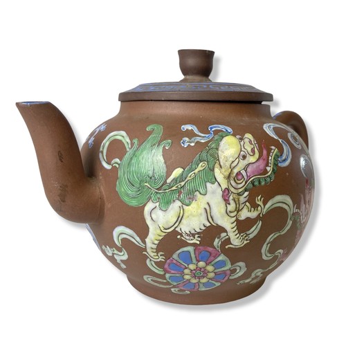 263 - A 19th-century Chinese Yixing teapot. Hand-painted in over-glaze enamels depicting Lions playing wit... 