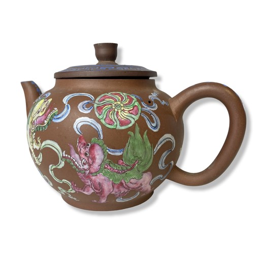 263 - A 19th-century Chinese Yixing teapot. Hand-painted in over-glaze enamels depicting Lions playing wit... 