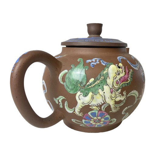 263 - A 19th-century Chinese Yixing teapot. Hand-painted in over-glaze enamels depicting Lions playing wit... 