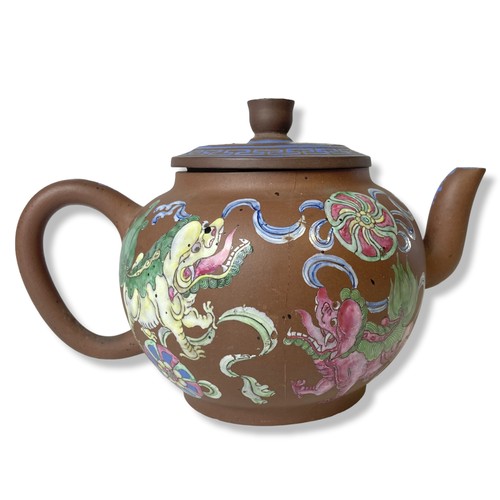 263 - A 19th-century Chinese Yixing teapot. Hand-painted in over-glaze enamels depicting Lions playing wit... 