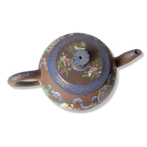 263 - A 19th-century Chinese Yixing teapot. Hand-painted in over-glaze enamels depicting Lions playing wit... 