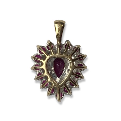 24 - A 9CT Gold, Ruby & Diamond pendant. With a central Pear cut Ruby with 16 surround Rubies and accent ... 