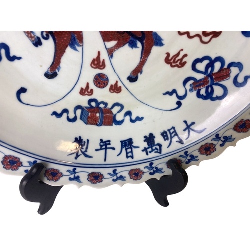 212 - A large Chinese porcelain Dish. Hand painted with polychrome central Pixiu. Bordered by various Budd... 